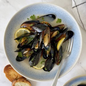 bowl of mussels with bread on side