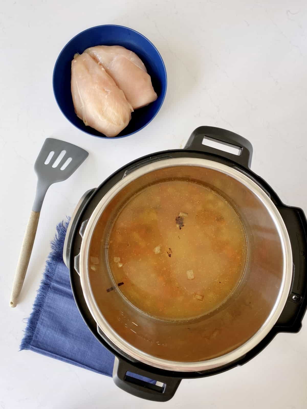 pot with broth and chicken on the side 