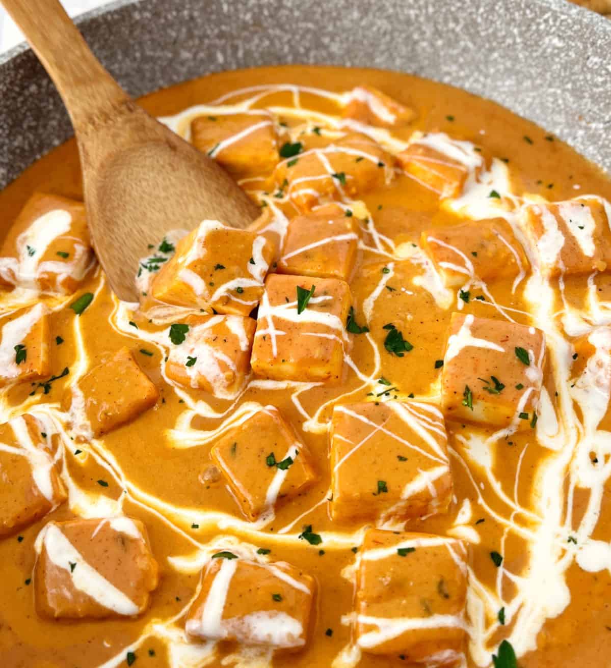 pan of paneer curry with cream on top 