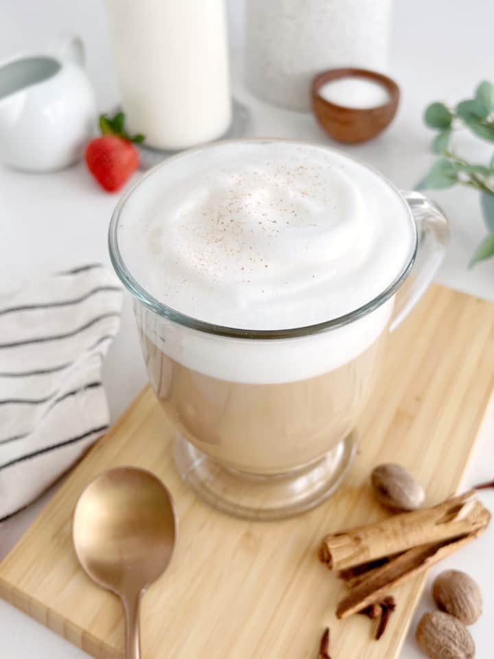 dirty chai latte on a wood board next to a spoon