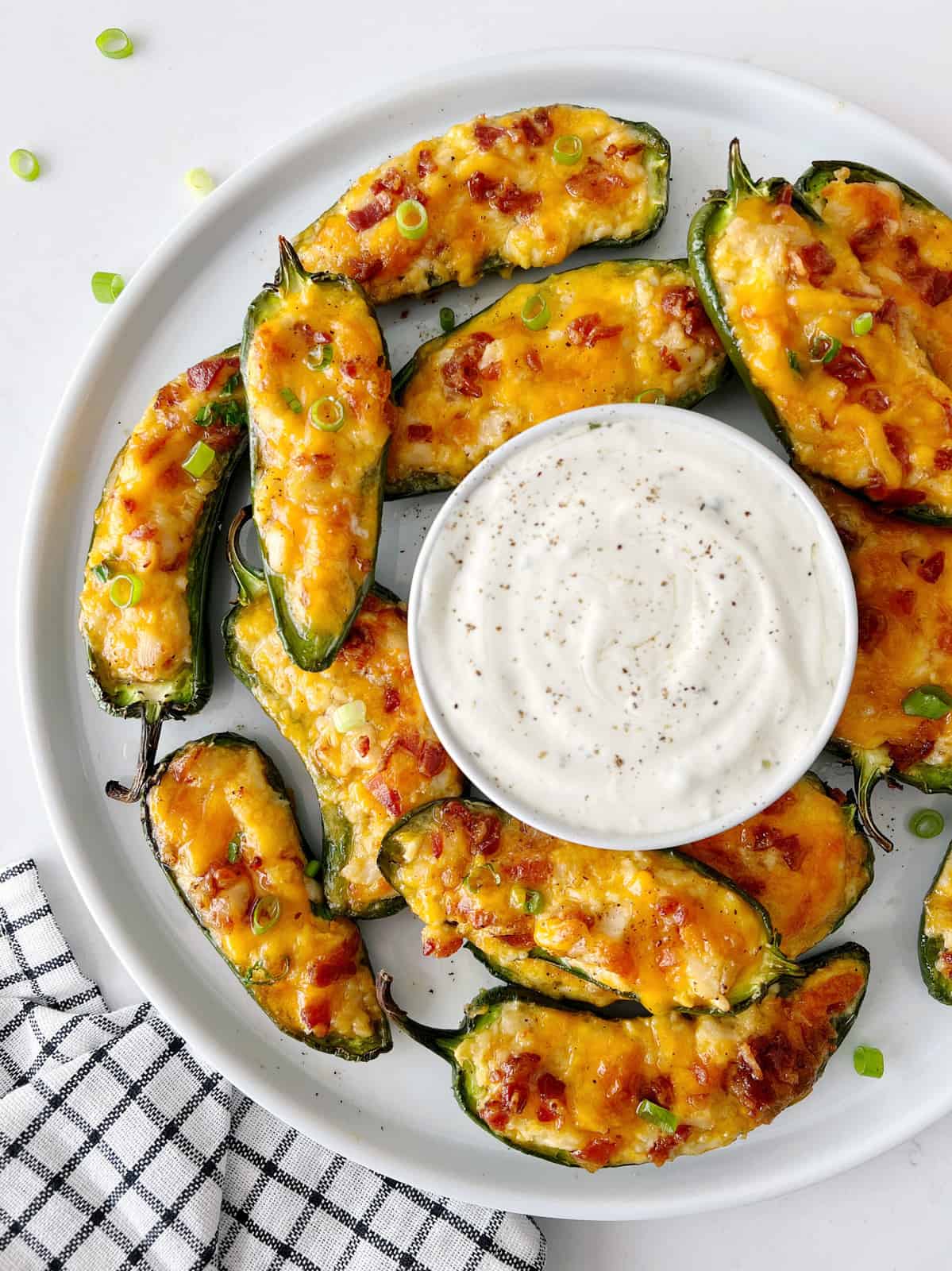 plate of jalapeno poppers with ranch dip in the middle 