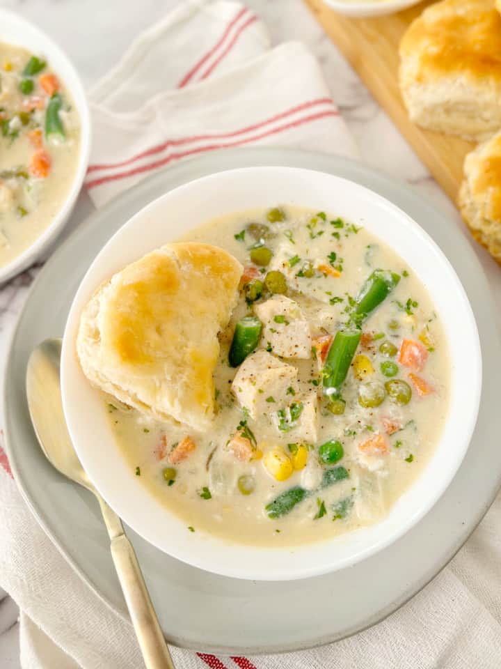 chicken pot pie in a bowl with biscuit