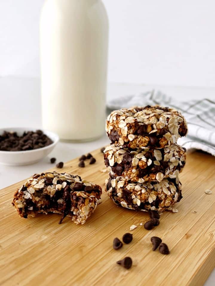 stack of cookies on a board with milk on the side