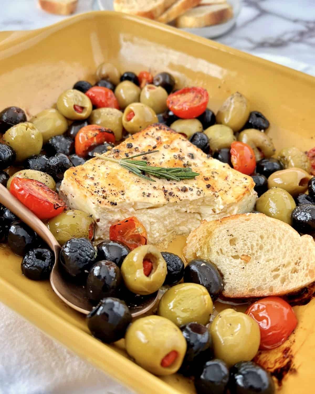bake feta with olives in a baking dish 