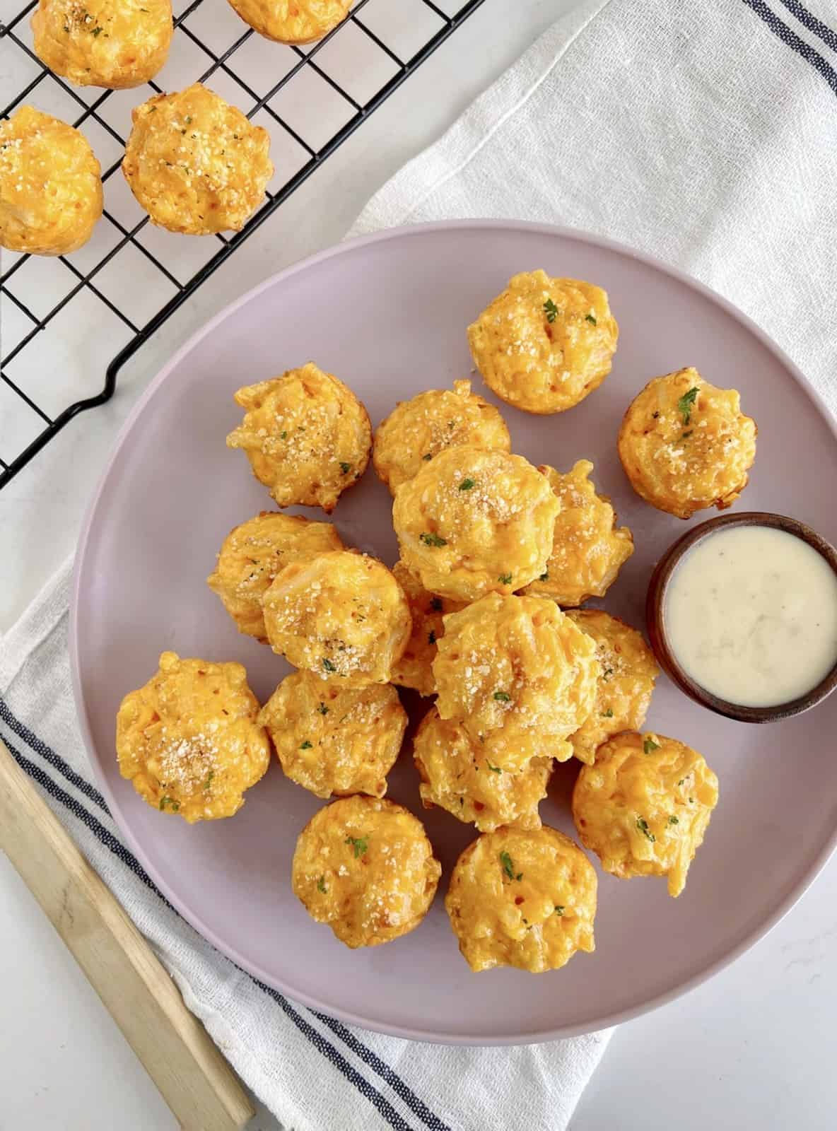 mac and cheese balls on a plate next to a baking rack 