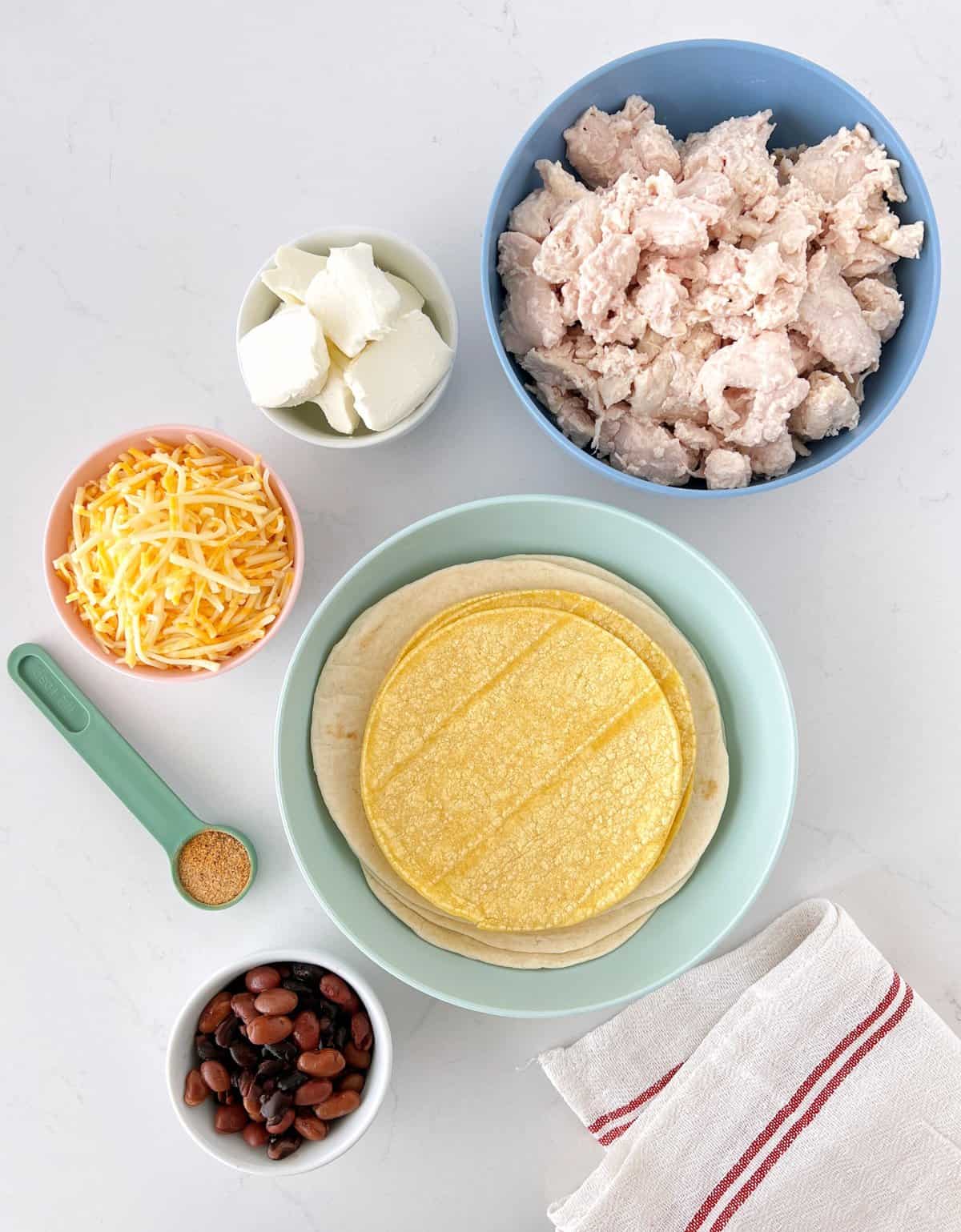 bowl of chicken, bowl of tortillas, cheese, and sour cream 