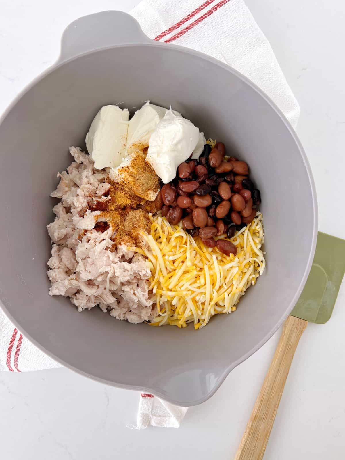 gray bowl with cheese, beans, sour cram and chicken 