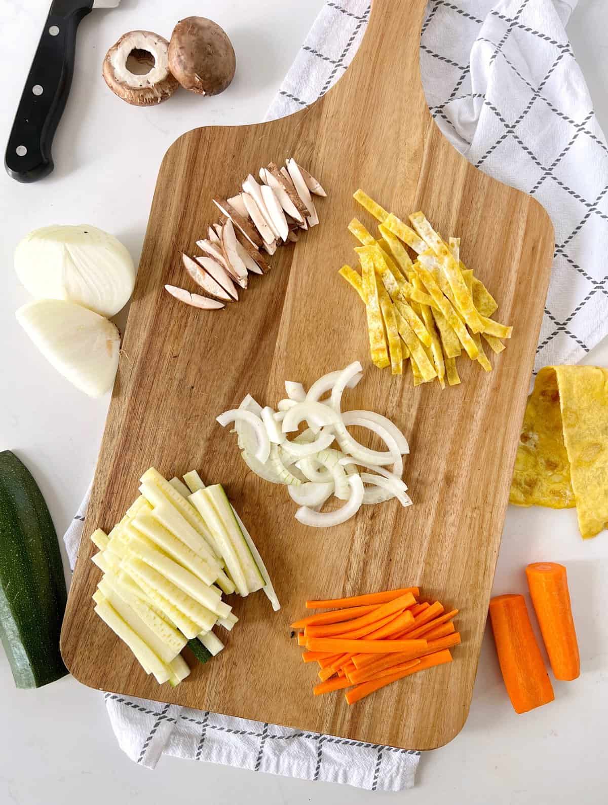 julienned vegetables on a wooden chopping board 