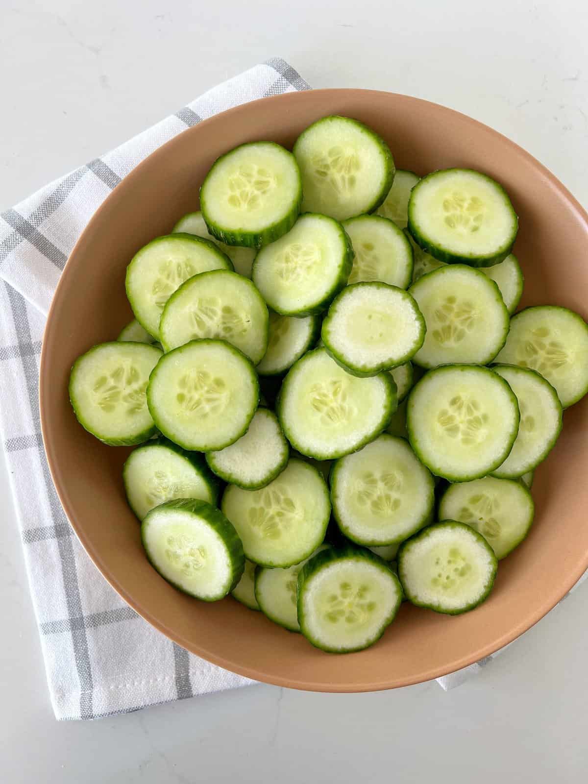 cut cucumbers in a wooden bowl 