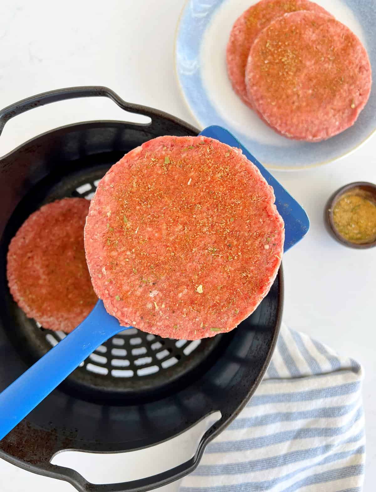 patties being placed in an air fryer 