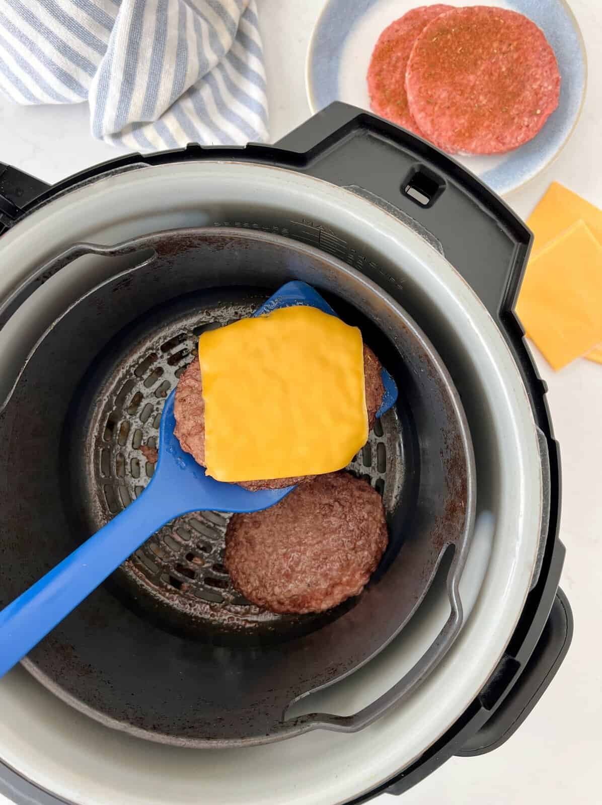air fryer with cooked patties and cheese 