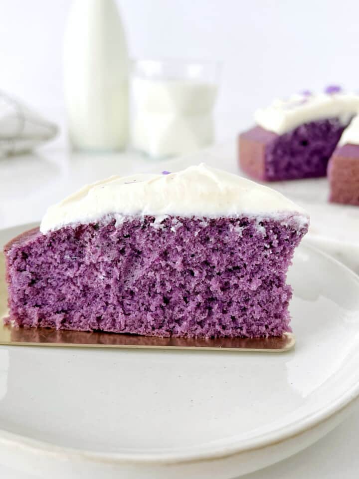 Slice of purple ube cake with white frosting