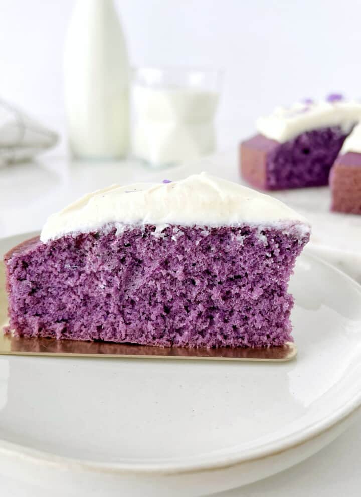 Slice of purple ube cake with white frosting