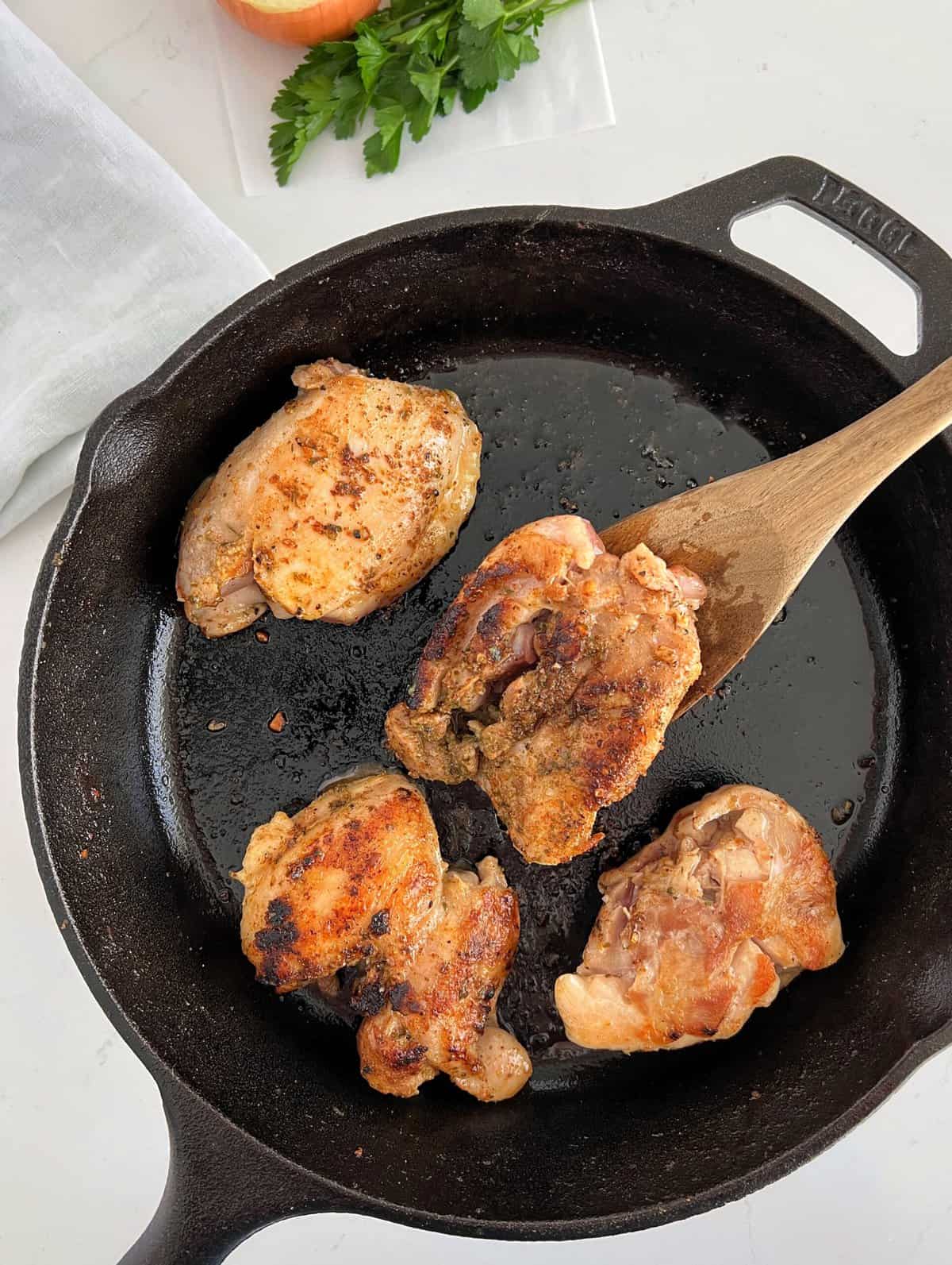 browned chicken thighs in cast iron skillet 