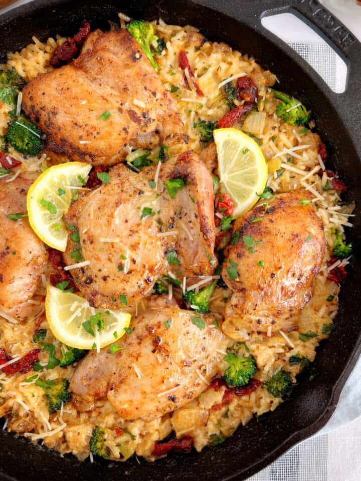 close up of baked tuscan chicken with rice and lemon
