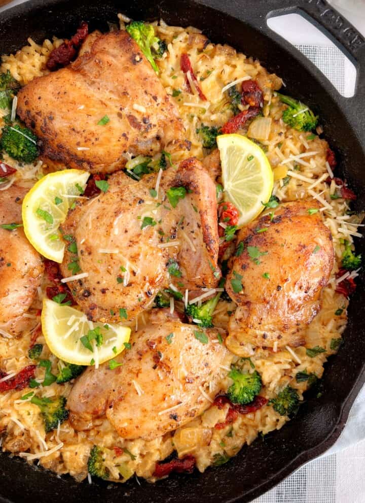 close up of baked tuscan chicken with rice and lemon