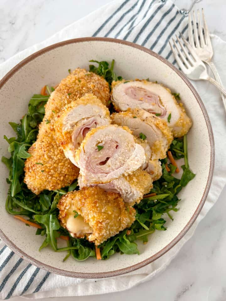 chicken cordon bleu on a bed of arugula