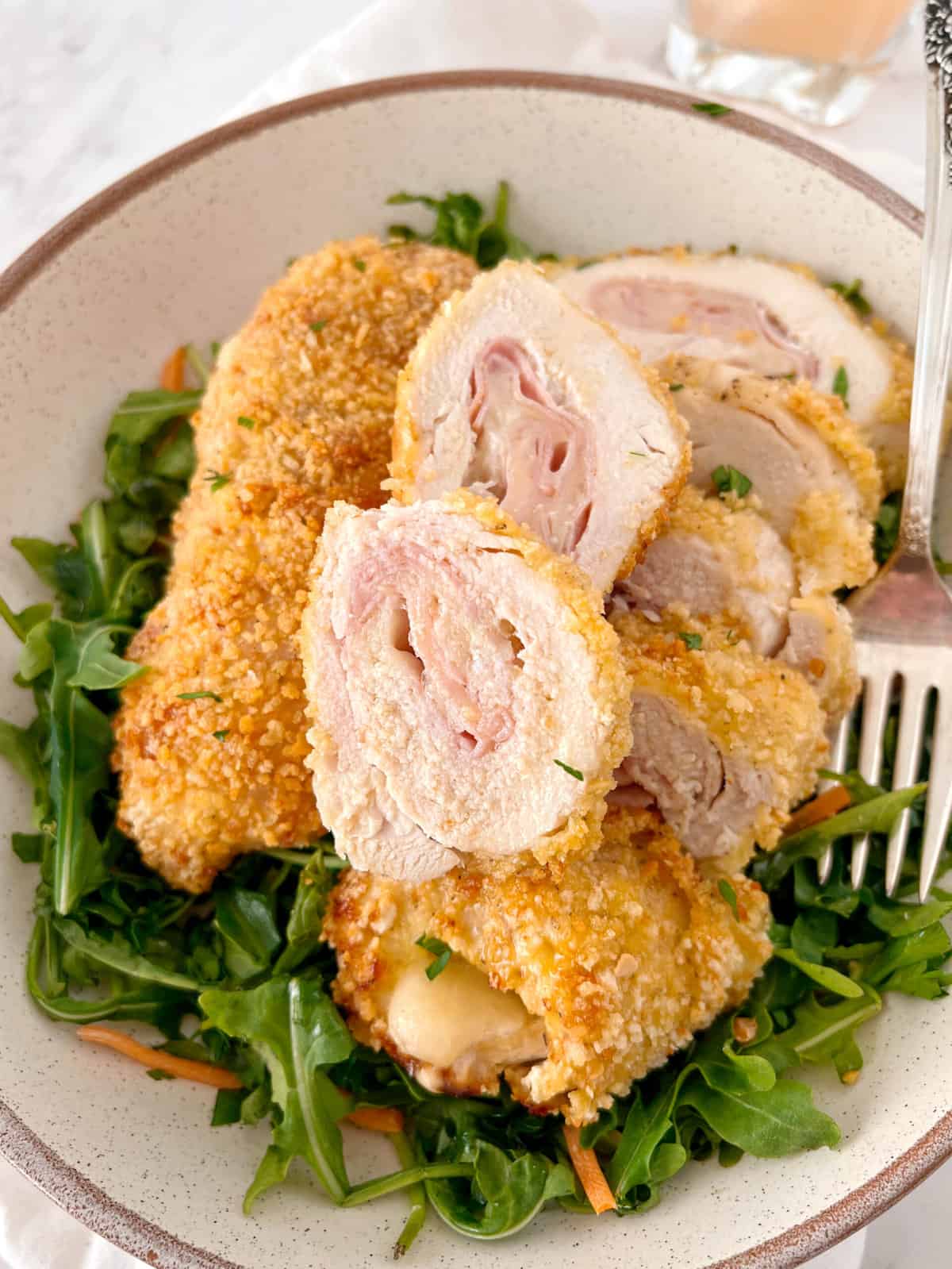 close up of chicken cordon bleu on a bed of arugula