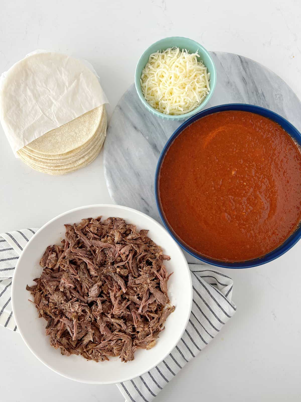 assembly station with tortillas, beef and cosume and cheese 