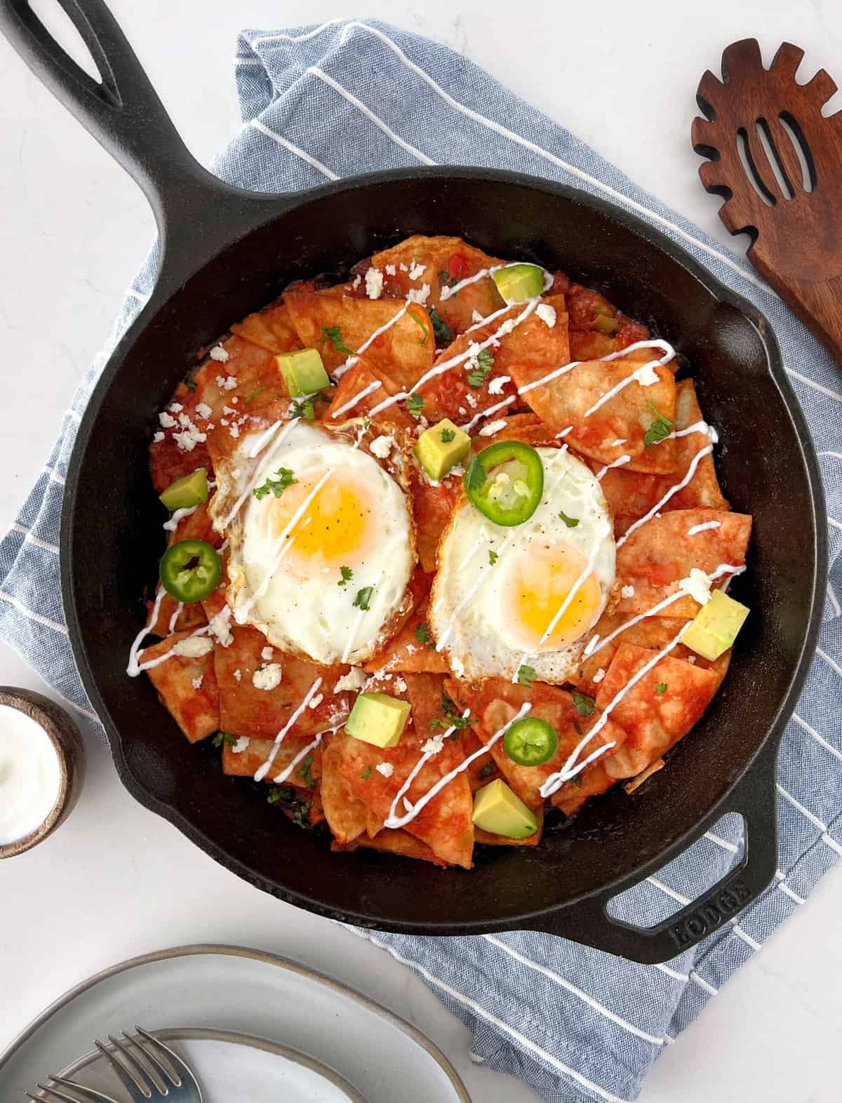 chilaquiles in a cast iron with eggs on top 