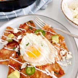 mexican chilaquiles on a plate with eggs on top