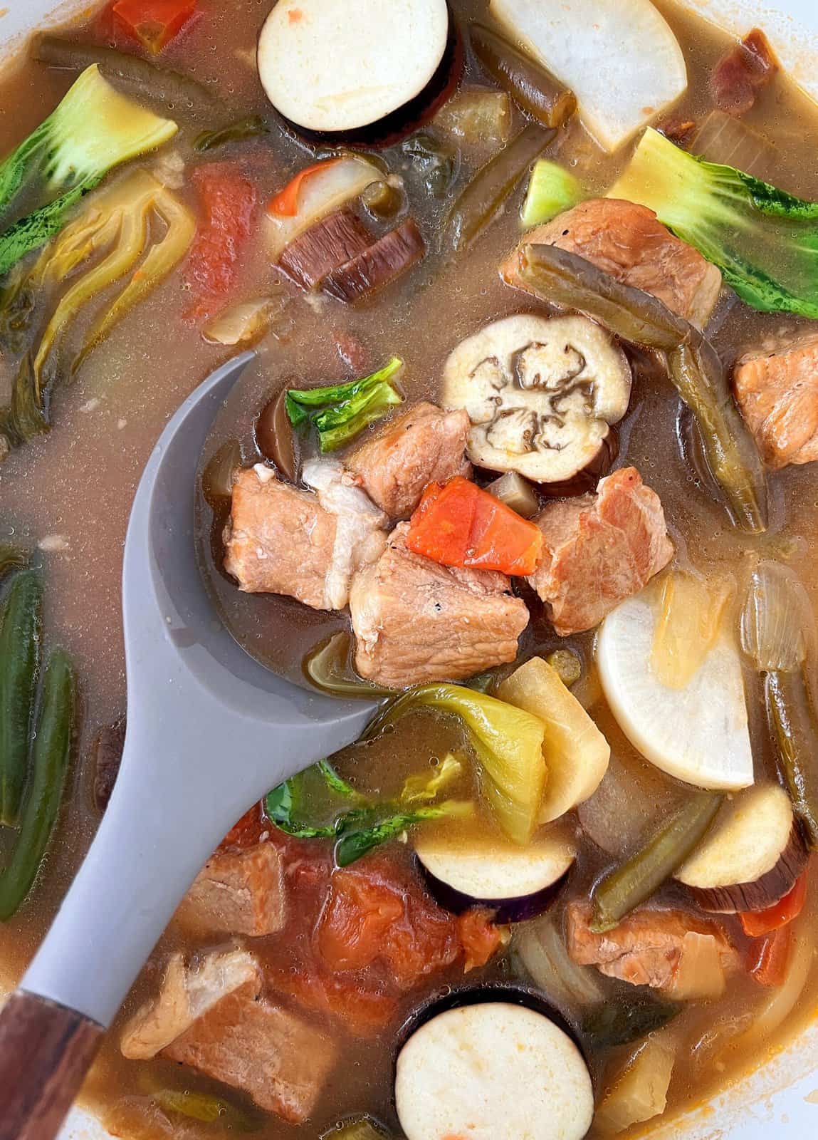 Pork sinigang soup with vegetables in a spoon 
