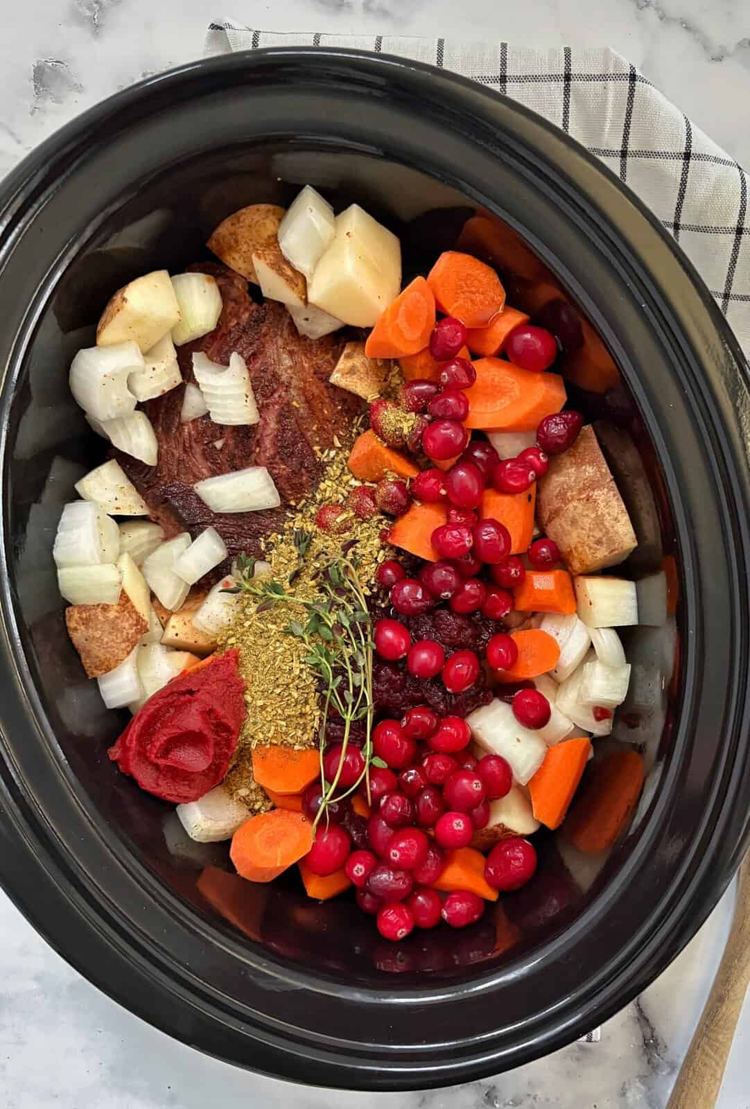 slow cooker with all the ingredients for cranberry pot roast
