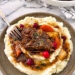 cranberry pot roast portion on a plate with mashed potatoes