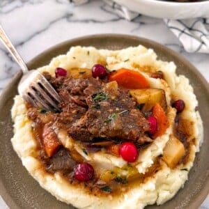 cranberry pot roast portion on a plate with mashed potatoes