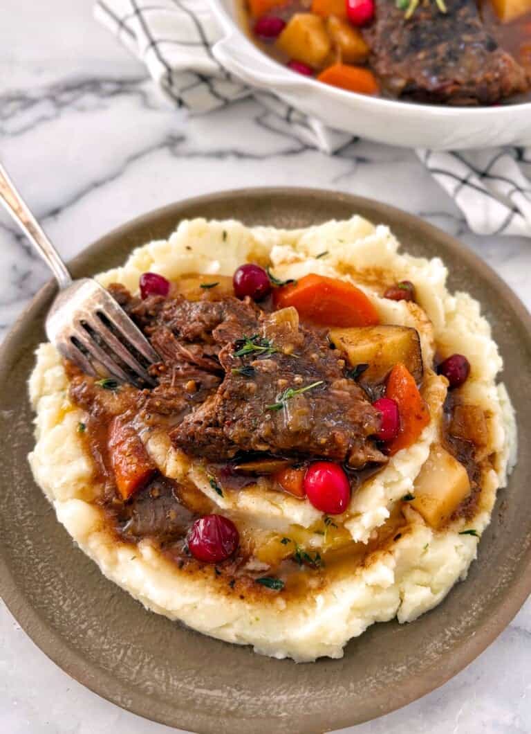 cranberry pot roast portion on a plate with mashed potatoes