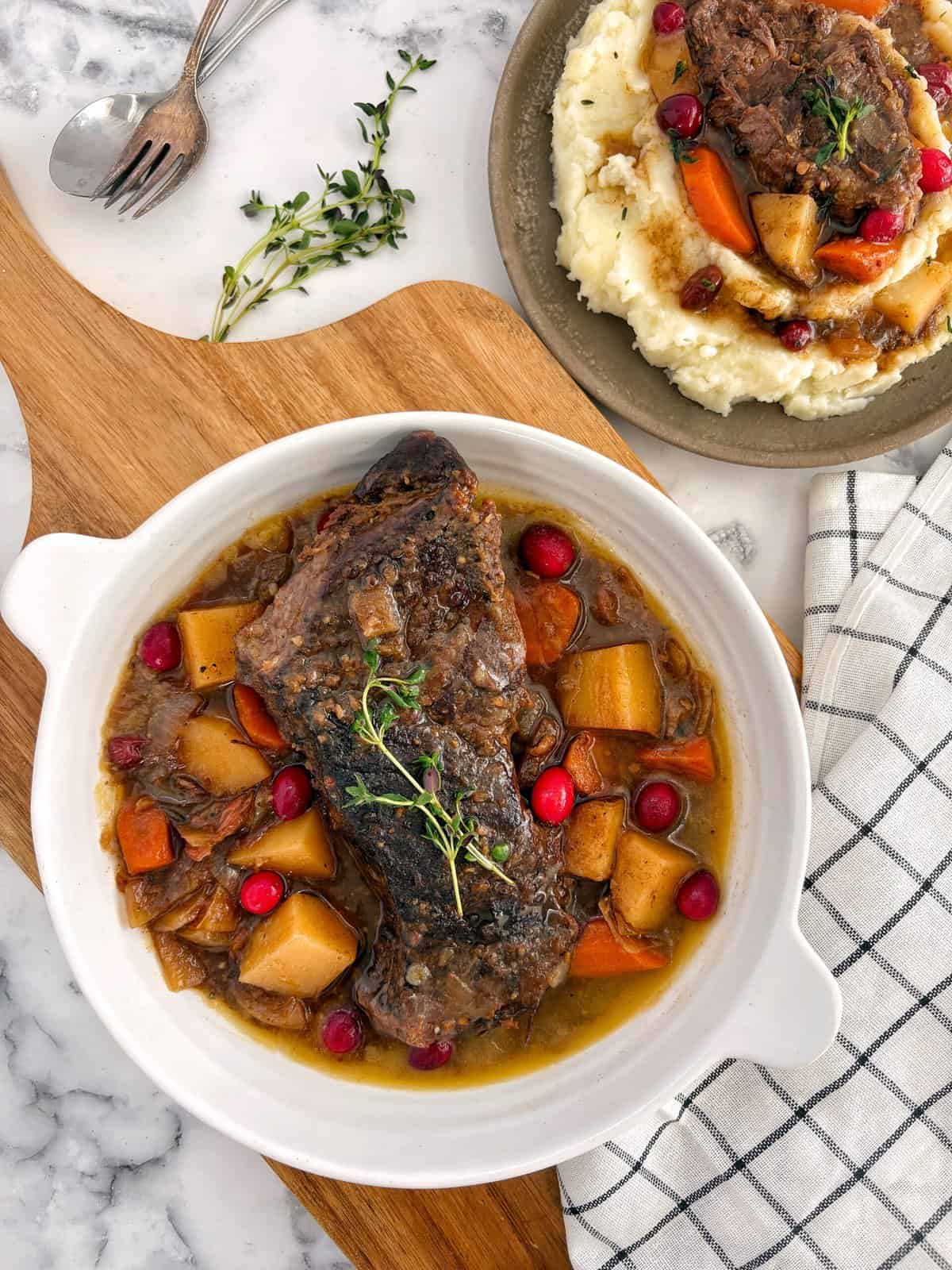 pot roast in a pot with side of mashed potatoes topped with pot roast