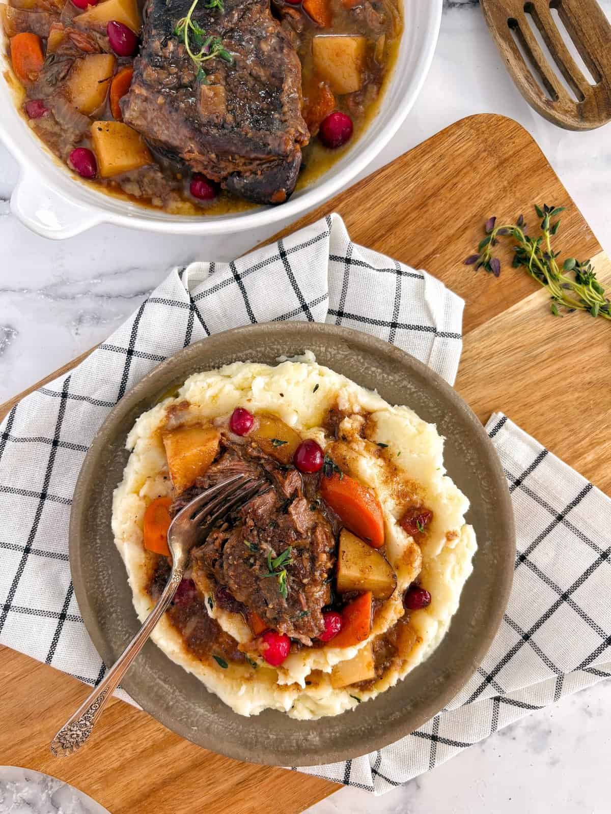 cranberry pot roast on mashed potatoes next to main dish