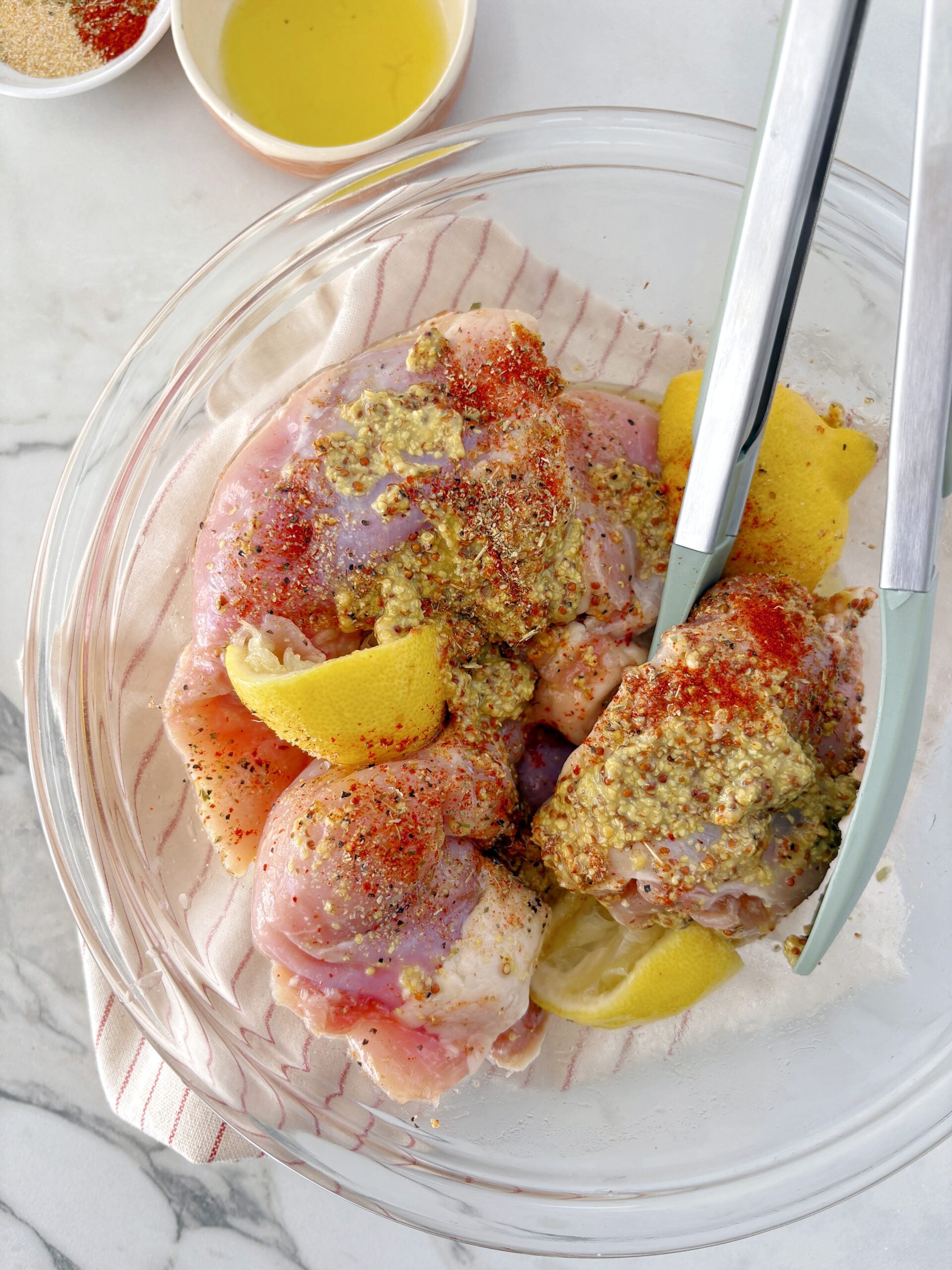 bowl with chicken and seasonings and lemon slices