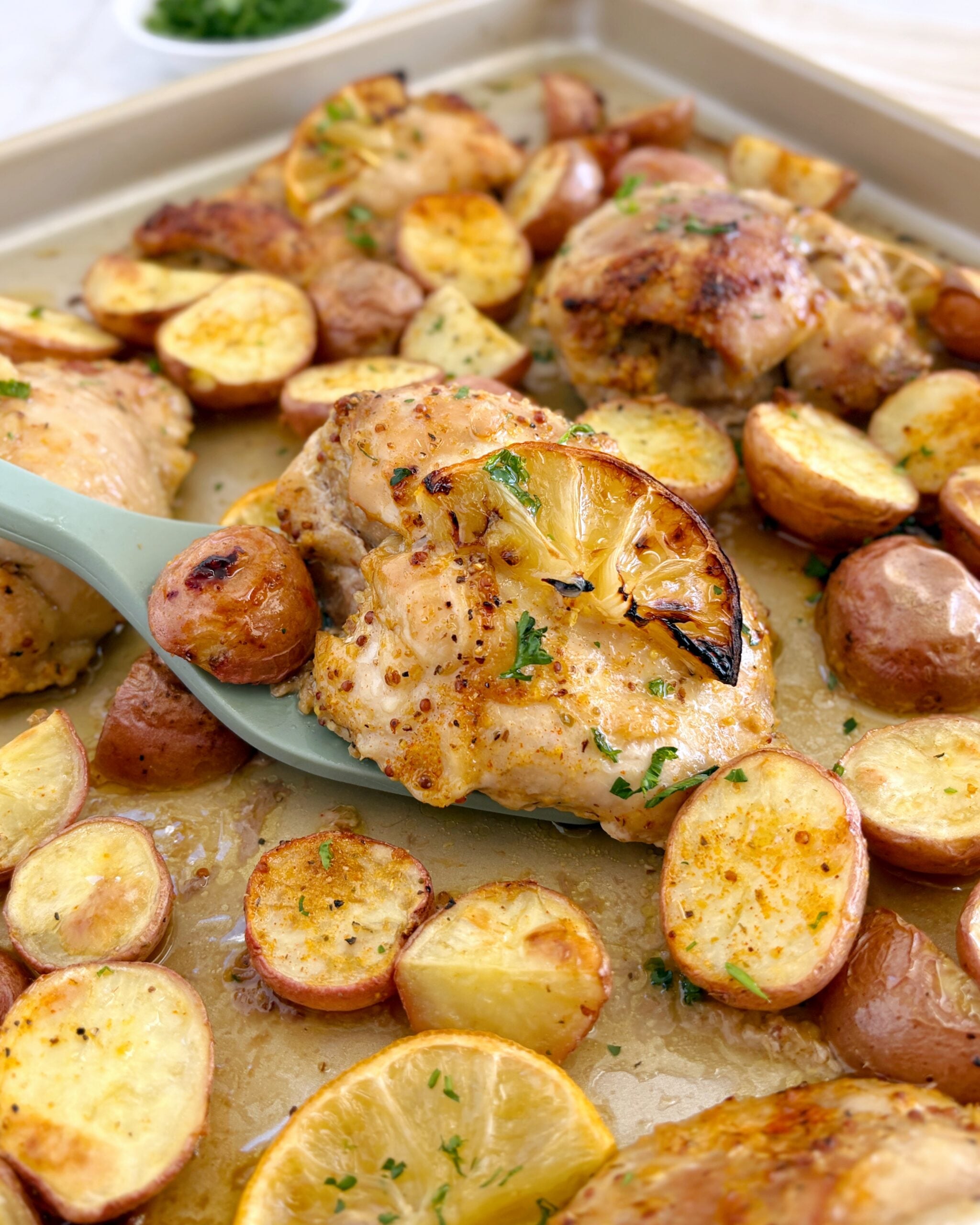 Lemon Chicken on baking sheet with potatoes